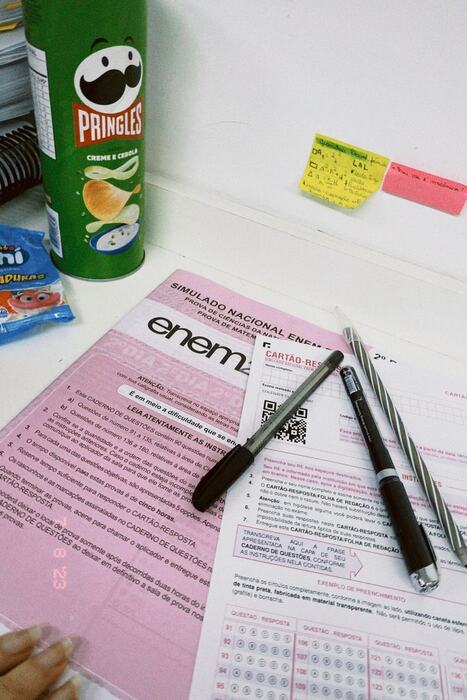 Simulado ENEM com cartão-resposta e material de estudo na mesa